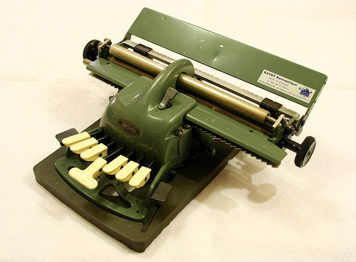 An antique green braille typewriter.